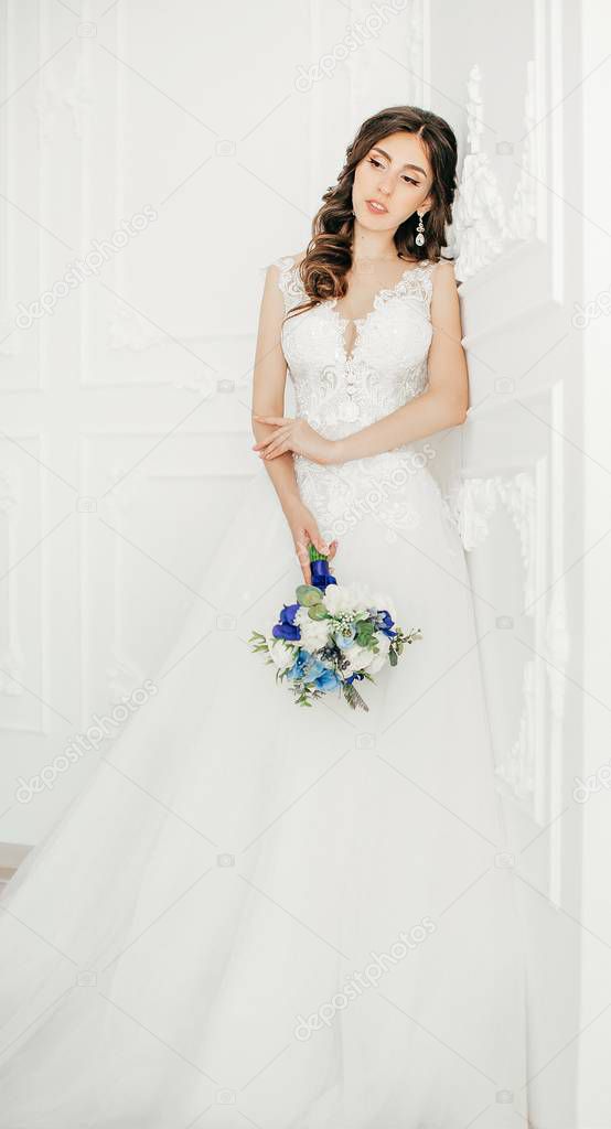 Beautiful young bride in white wedding dress posing  
