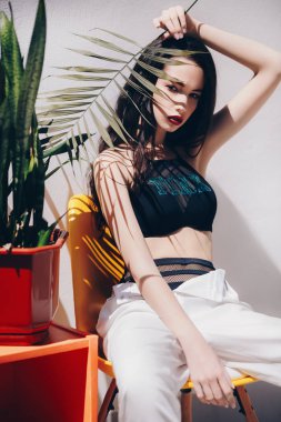 Güzel genç kadın üst ve beyaz pantolonuyla poz