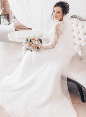 Güzel genç gelin çiçekleri ile poz beyaz gelinlik