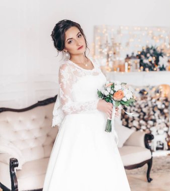 Güzel genç gelin çiçekleri ile poz beyaz gelinlik