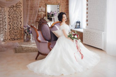 Güzel genç gelin çiçekleri ile poz beyaz gelinlik