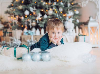 Hediyeler ile Noel ağacı yakınındaki mutlu küçük çocuk portresi  