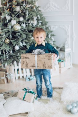 Hediyeler ile Noel ağacı yakınındaki mutlu küçük çocuk portresi  
