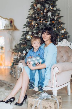 Mutlu anne ve oğul portresi Noel ağacı yakınındaki 