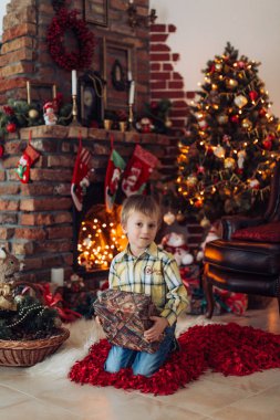 Hediyeler ile Noel ağacı yakınındaki mutlu küçük çocuk portresi  