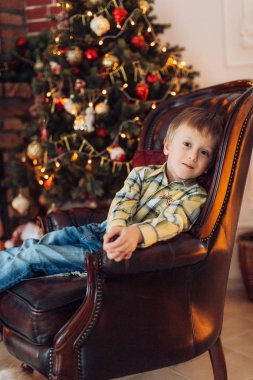 Hediyeler ile Noel ağacı yakınındaki mutlu küçük çocuk portresi  