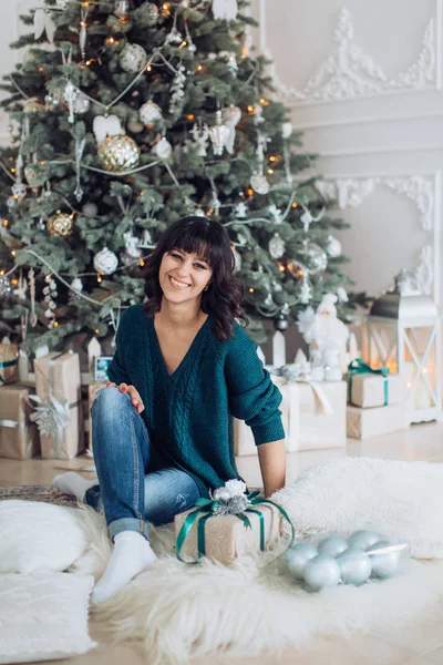 Beautiful woman  near Christmas tree posing at home