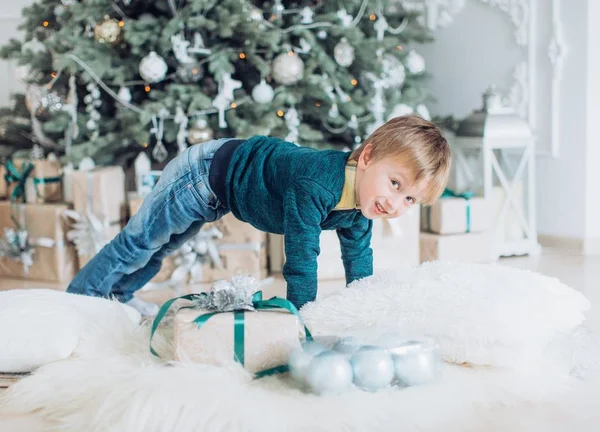 プレゼントとクリスマス ツリーの近く幸せな小さな男の子の肖像画 — ストック写真