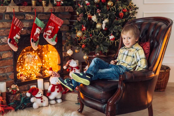 Hediyeler ile Noel ağacı yakınındaki mutlu küçük çocuk portresi  