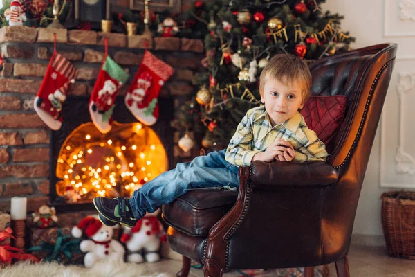 Hediyeler ile Noel ağacı yakınındaki mutlu küçük çocuk portresi  