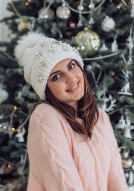 Noel ağacı evde poz yakınındaki kış şapkalı güzel kadın 
