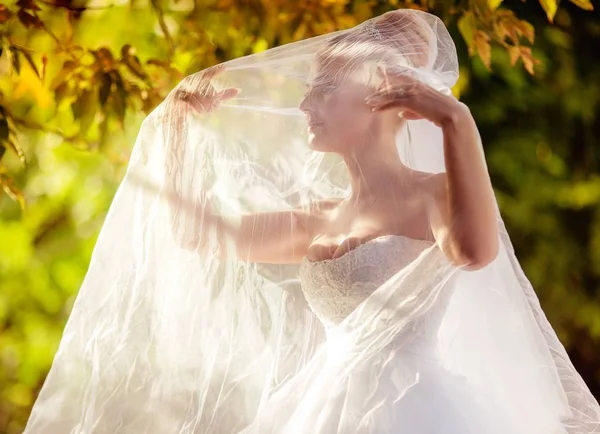 美丽的年轻新娘在白色婚纱摆姿势在公园 — 图库照片