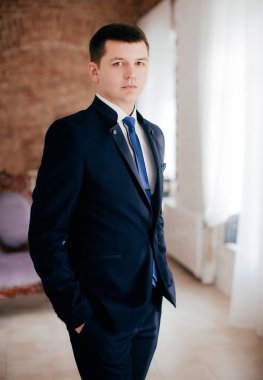 Yakışıklı damat gülümseyen ve gelin için bekliyor. Mutlu gülümseyen damat yeni evli