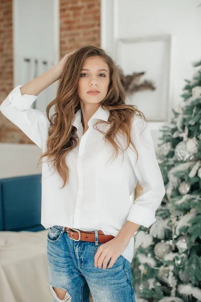 Güzel genç kız evde Noel ağacı poz yakınındaki eğlence var 