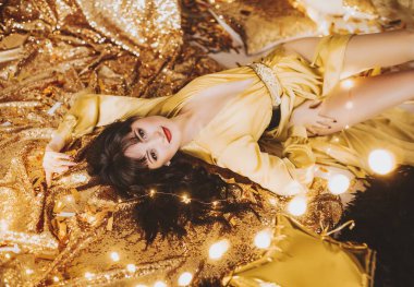 Altın elbiseyle poz güzel genç kadın