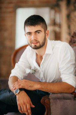 Yakışıklı damat gülümseyen ve gelin için bekliyor. Mutlu gülümseyen damat yeni evli