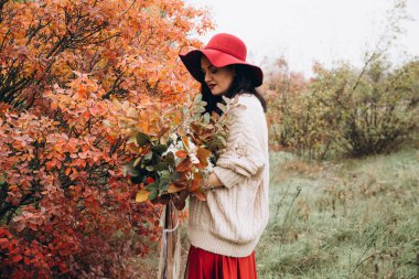 Sonbahar parkında poz veren güzel genç kadının portresi