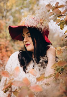 Sonbahar parkında poz veren güzel genç kadının portresi