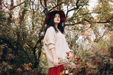 Sonbahar parkında poz veren güzel genç kadının portresi