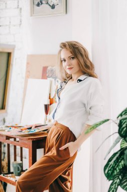 Odada poz veren genç ve güzel sanatçı kadın