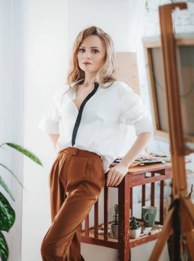 Odada poz veren genç ve güzel sanatçı kadın