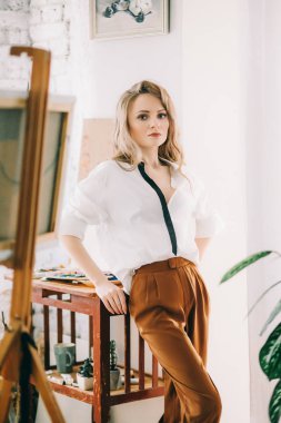 Odada poz veren genç ve güzel sanatçı kadın