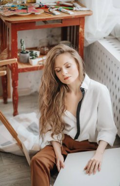 Odada poz veren genç ve güzel sanatçı kadın