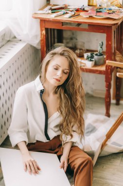 Odada poz veren genç ve güzel sanatçı kadın