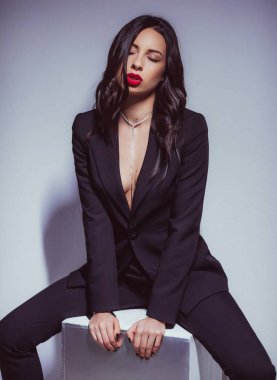 Siyah kostümlü güzel genç kadın poz