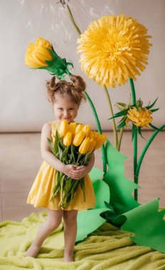Sarı çiçeklerile güzel küçük kız portresi 