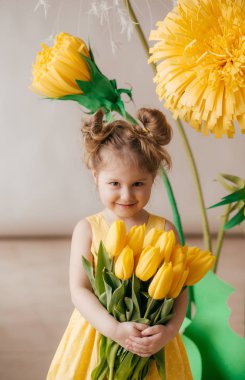 Sarı çiçeklerile güzel küçük kız portresi 