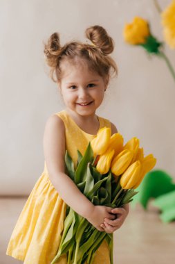 Sarı çiçeklerile güzel küçük kız portresi 