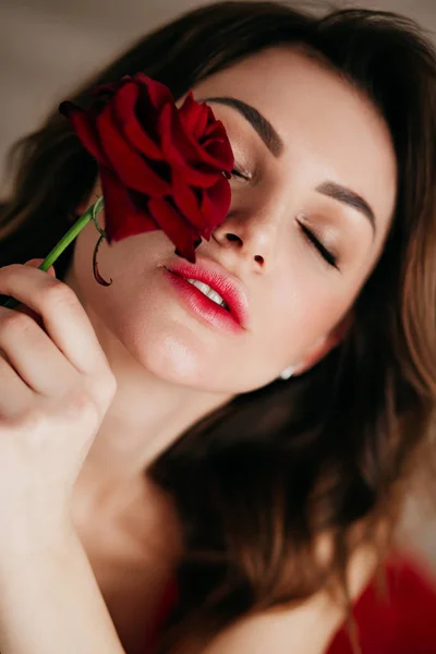 Image of Portrait of a Beautiful Young Woman Standing And Posing With A Red  Rose In Hand On an Isolated white Background-JO573220-Picxy