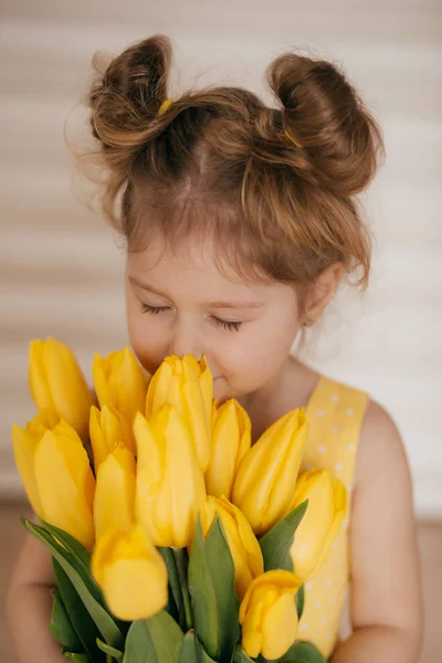 美丽的小女孩与黄色的花朵的肖像 — 图库照片