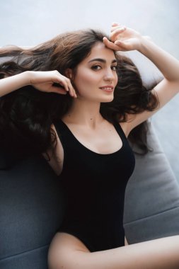  Stüdyoda poz veren siyah mayo giymiş güzel bir kadın.