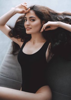  Stüdyoda poz veren siyah mayo giymiş güzel bir kadın.