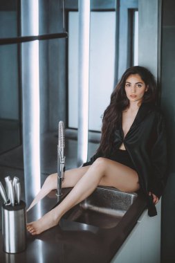  evde poz siyah giysiler içinde makyaj ile güzel genç kadın