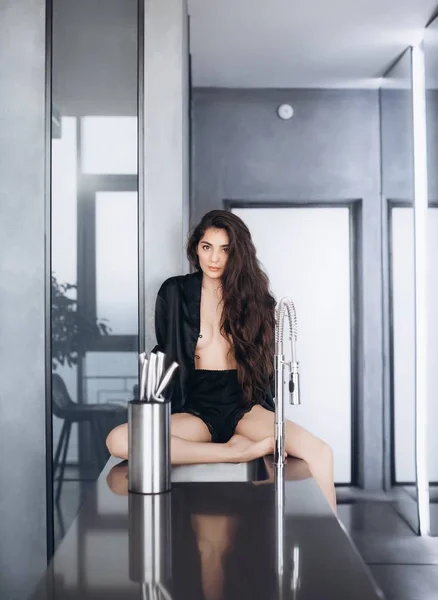 自宅でポーズ黒い服を着た化粧をした美しい若い女性 — ストック写真