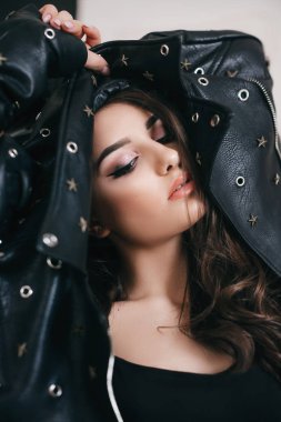  stüdyoda poz makyaj ve deri ceket ile güzel kadın