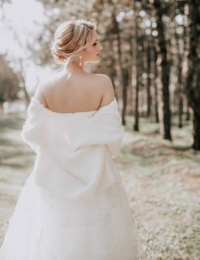 Parkta poz beyaz gelinlikle güzel genç gelin  