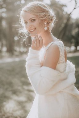 Parkta poz beyaz gelinlikle güzel genç gelin  