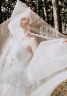 Parkta poz beyaz gelinlikle güzel genç gelin  