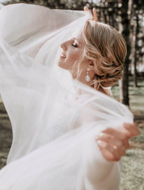 Parkta poz beyaz gelinlikle güzel genç gelin  