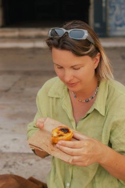 Gen Z orta yaşlı kadın Lizbon 'da fırın yakınlarında Pastel de Nata adında Portekiz yumurtalı tart tatlısı deniyor. Yalnız turizm ve seyahat. Bir serinin parçası