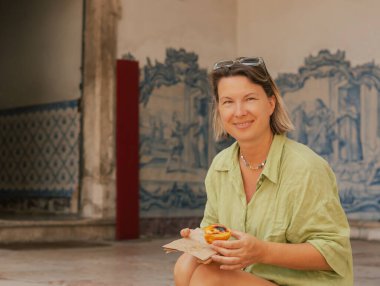 Gen Z orta yaşlı kadın Lizbon 'da fırın yakınlarında Pastel de Nata adında Portekiz yumurtalı tart tatlısı deniyor. Yalnız turizm ve seyahat. Bir serinin parçası