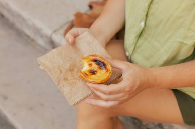 Gen Z orta yaşlı kadın Lizbon 'da fırın yakınlarında Pastel de Nata adında Portekiz yumurtalı tart tatlısı deniyor. Yalnız turizm ve seyahat. Bir serinin parçası