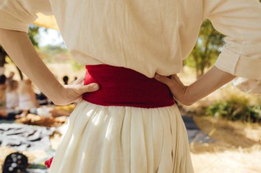Close-up of Ukrainian traditional costume embroidered vyshyvanka blouse, woven belt kraika, folk jewelry. Ethnic festive clothing, national outfit details, cultural heritage. Part of the series.
