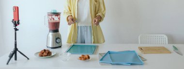 Orta yaşlı bir kadın ev yapımı meyve derisi hazırlıyor, sağlıklı atıştırmalıklar için mutfağında taze meyve dilimliyor. Organik ikramlar ve doğal yaşam üzerine bir serinin parçası. Kullanıcı kaynaklı içerik. Canlı yayın.