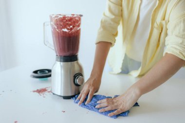 Kadınların elleri sağlıklı bir organik diyet için sağlıklı bir yaşam tarzı fotoğraf serisinin bir parçası olarak sağlıklı bir organik diyet için taze meyve blendırında smoothie hazırlıyor.