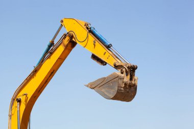 mavi gökyüzü arkaplanındaki kazı sırasında turuncu sürüngen kazıcı